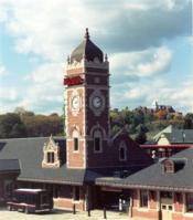 Phptp of brick Train Station building - which features a tower displaying a large clock